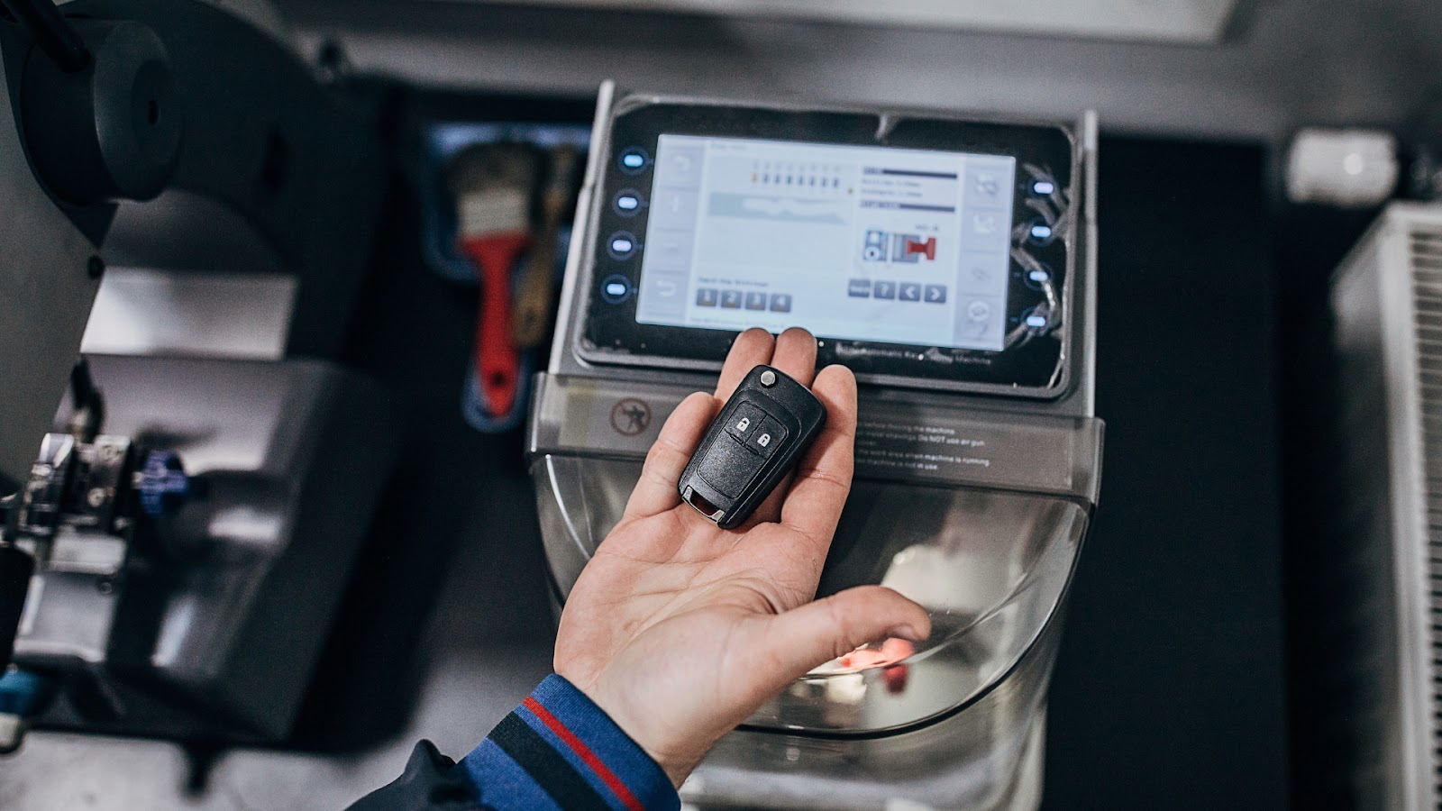 An auto locksmith duplicating a car key