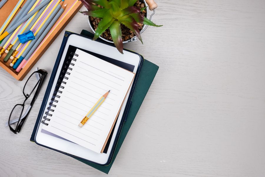 A notebook and pencil on top of books