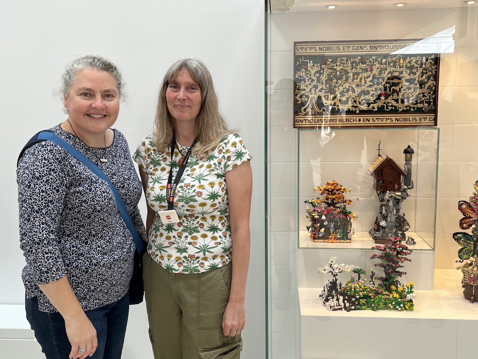 A photo of Gayle Spiller standing with Alice Finch beside Gayle's creations displayed in the Masterpiece Gallery