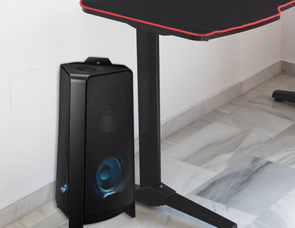 Samsung Sound Tower speaker placed next to a computer desk