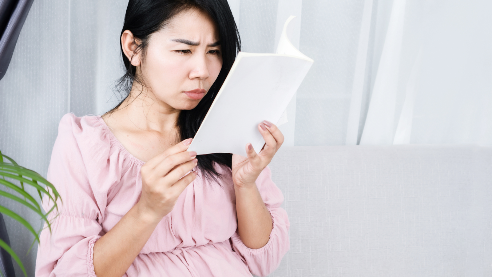 A woman struggling to read due to blurry vision caused by diabetes