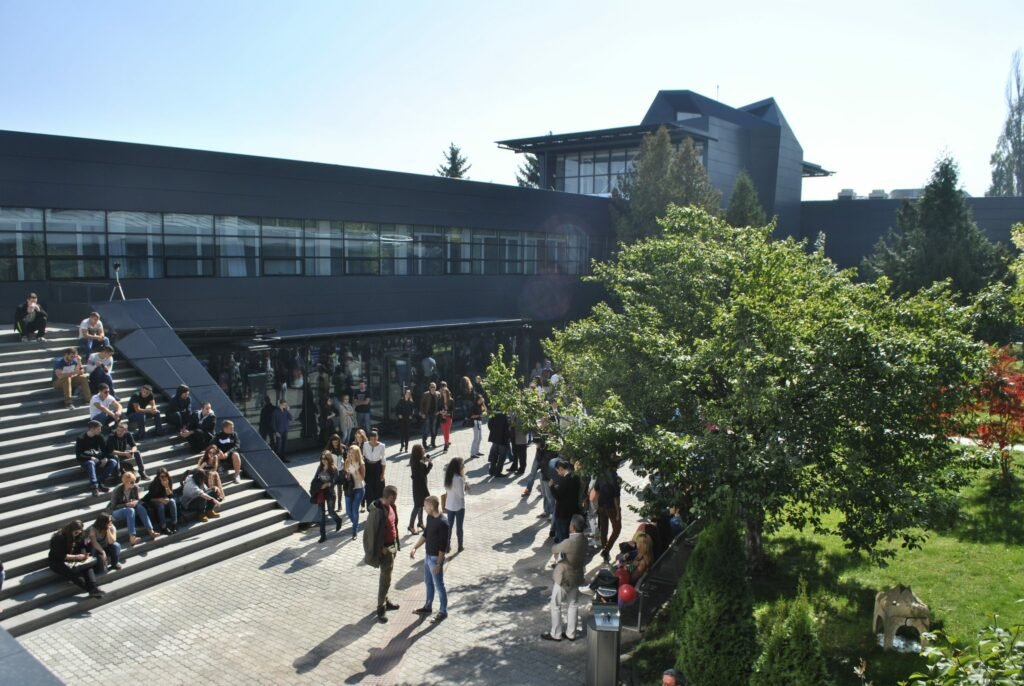 Article on "Welcome to New Bulgarian University: A Hub of Education and Innovation" picture of the university with students sitting on the steps