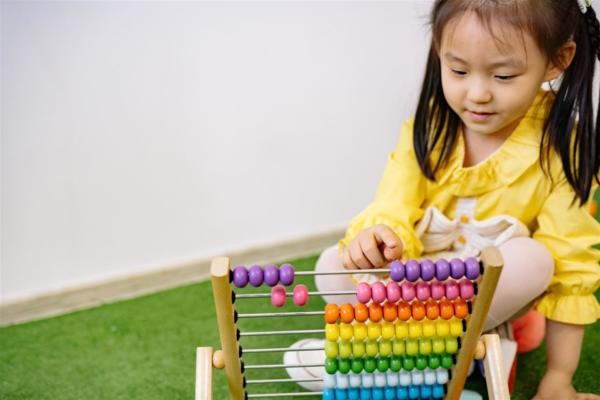 A Kid performing Calculations on Abacus beads