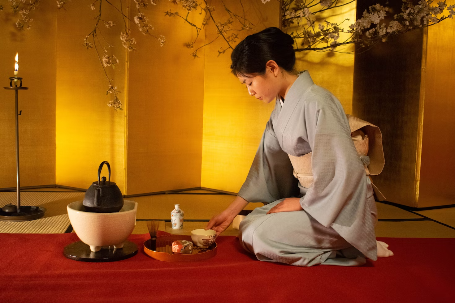 Woman in kimono practicing Japanese tea ceremony