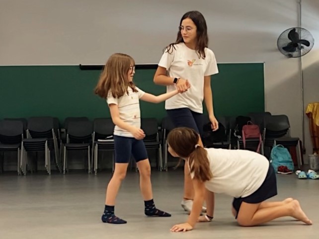 professora e crianças tendo aula de teatro