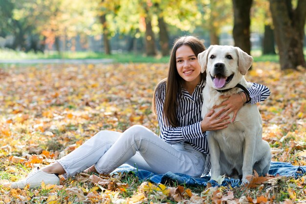 A woman smiling and hugging her dog.