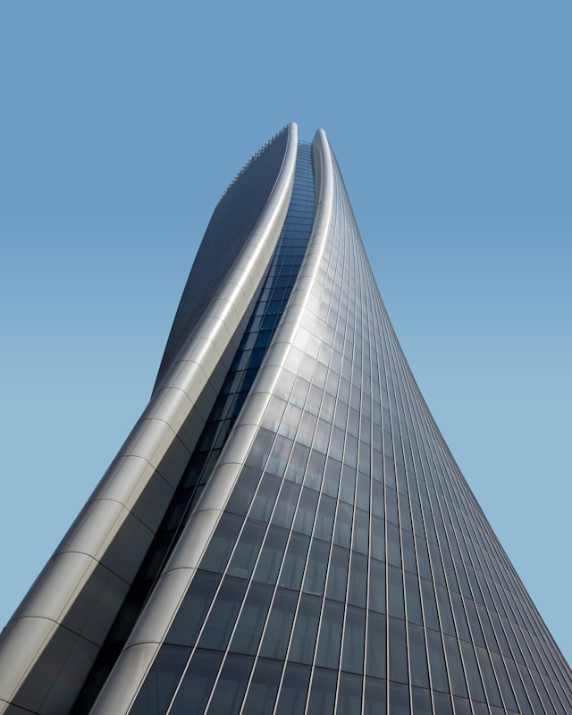 A gray metallic spiral skyscraper designed using parametric design principles