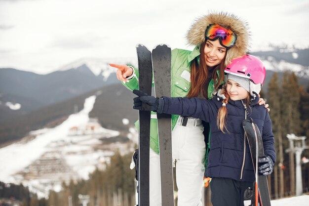 Free photo mother with daughter skiing. people in the snowy mountains.
