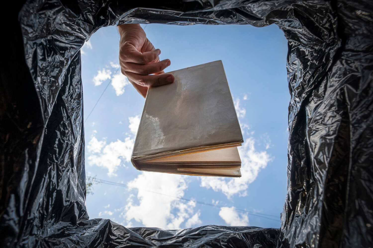 libro siendo tirado en una basura