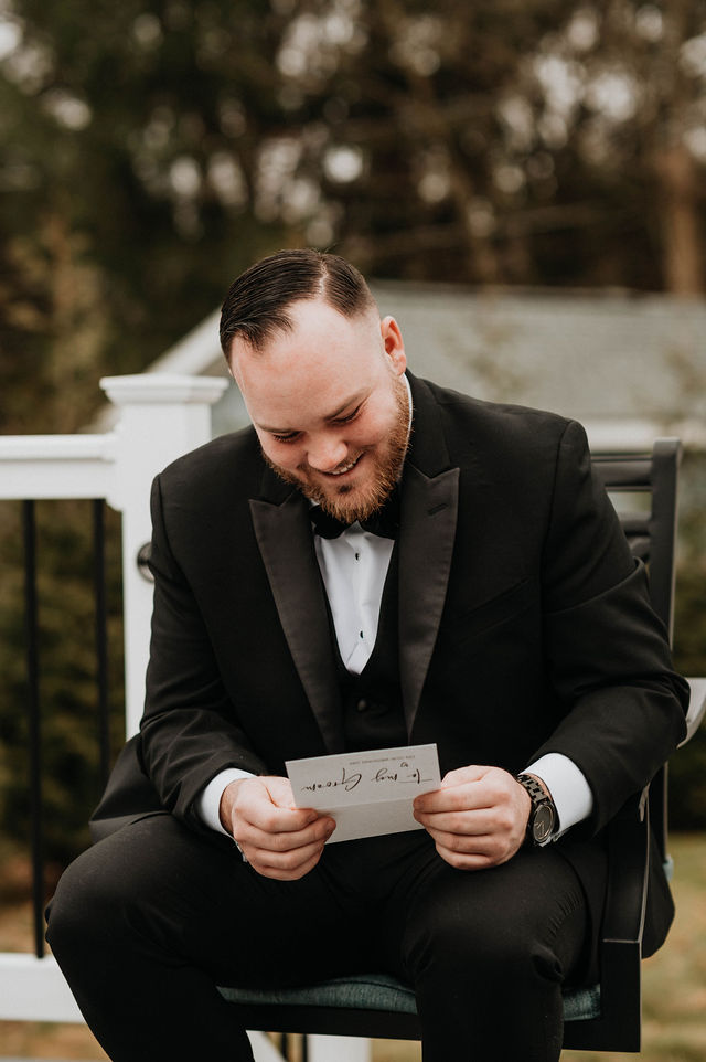 Groom reads a letter given to him as a wedding day gift.