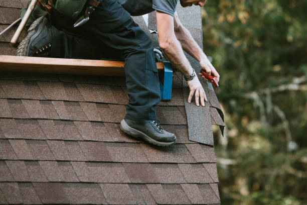 A roofer and crew work on putting in new roofing shingles.
