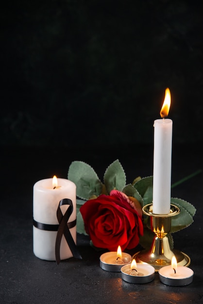 Free photo front view of burning candles with red flower on dark surface