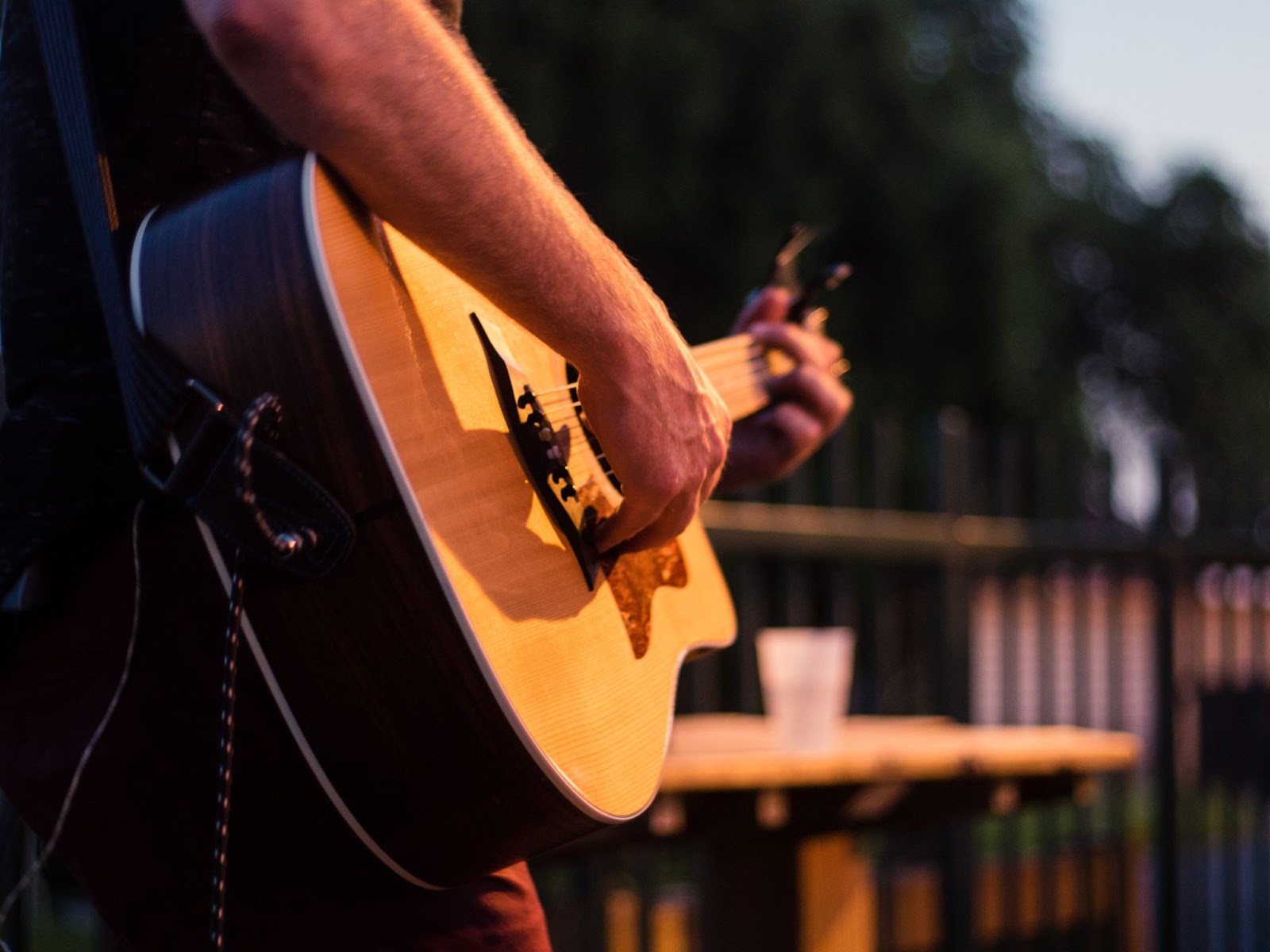 a closeup of a musicians guitar at an outdoor live music performance in kelowna