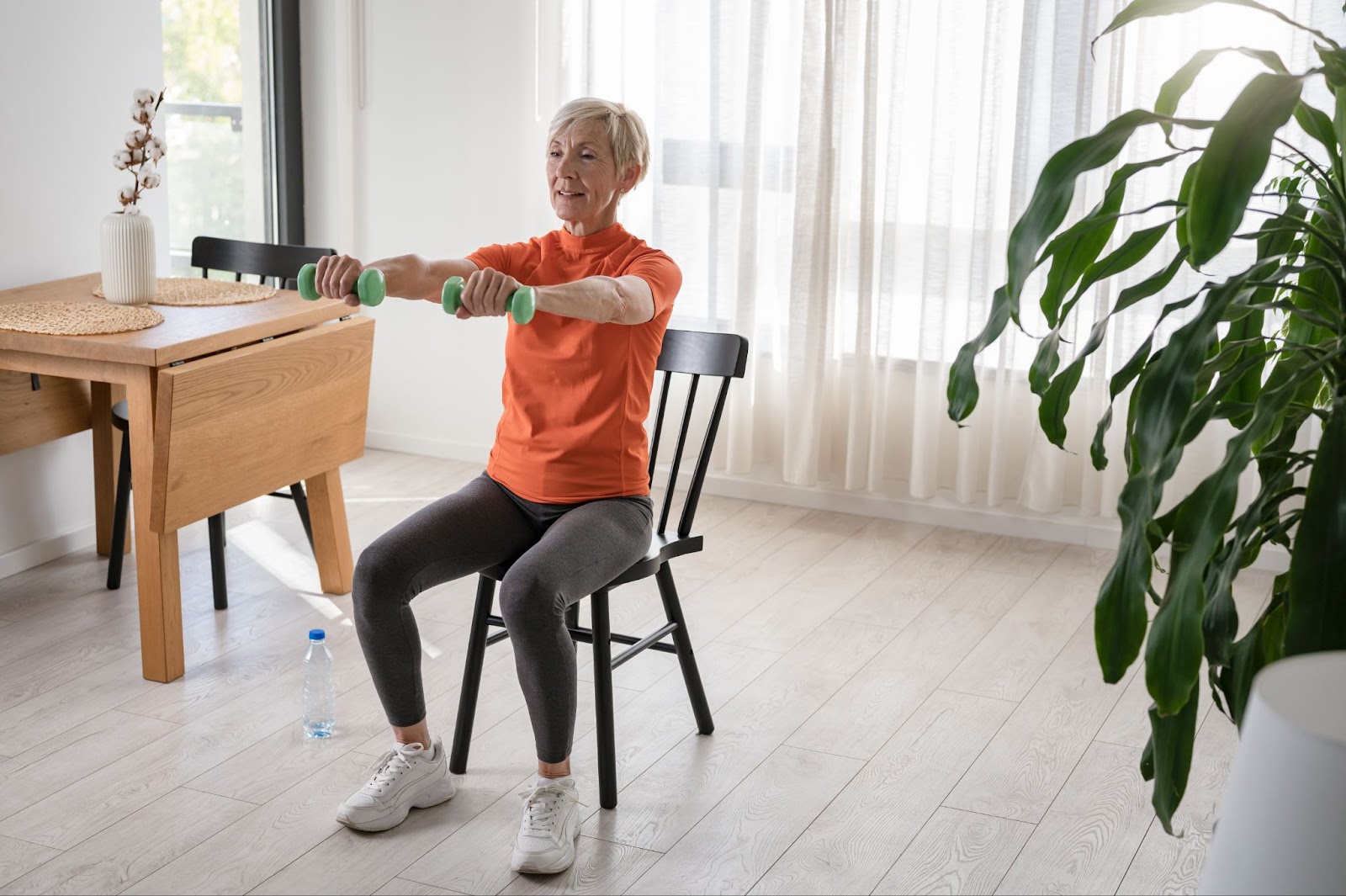 Smiling mature woman exercising while seated indoors.