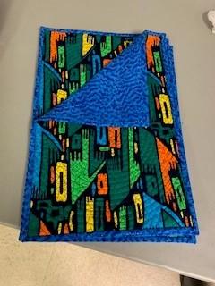 A folded blue cloth with colorful designs

Description automatically generated
