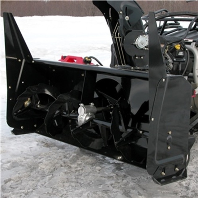 A front-oblique, close-up view of a Yamaha RMAX Snowblower by Bercomac, installed on a vehicle and parked on snowy terrain.
