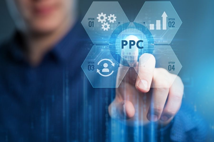 Business professional pointing at a transparent futuristic interface with various icons and the acronym PPC illuminated in the center.