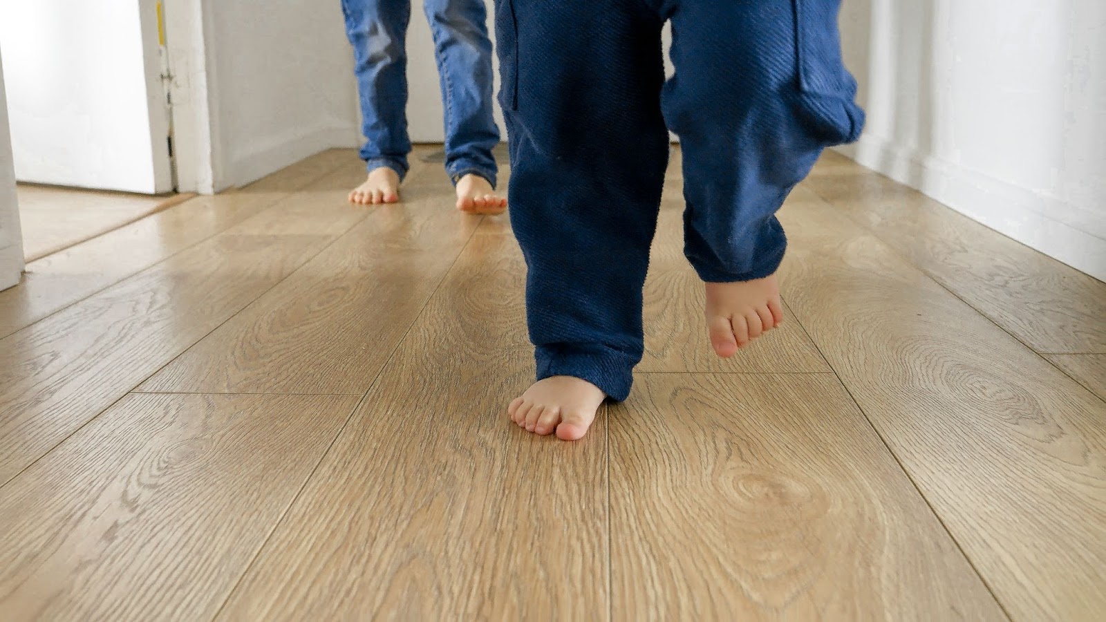 The sight of happy children's feet dancing on the wooden floor in the house's corridor.