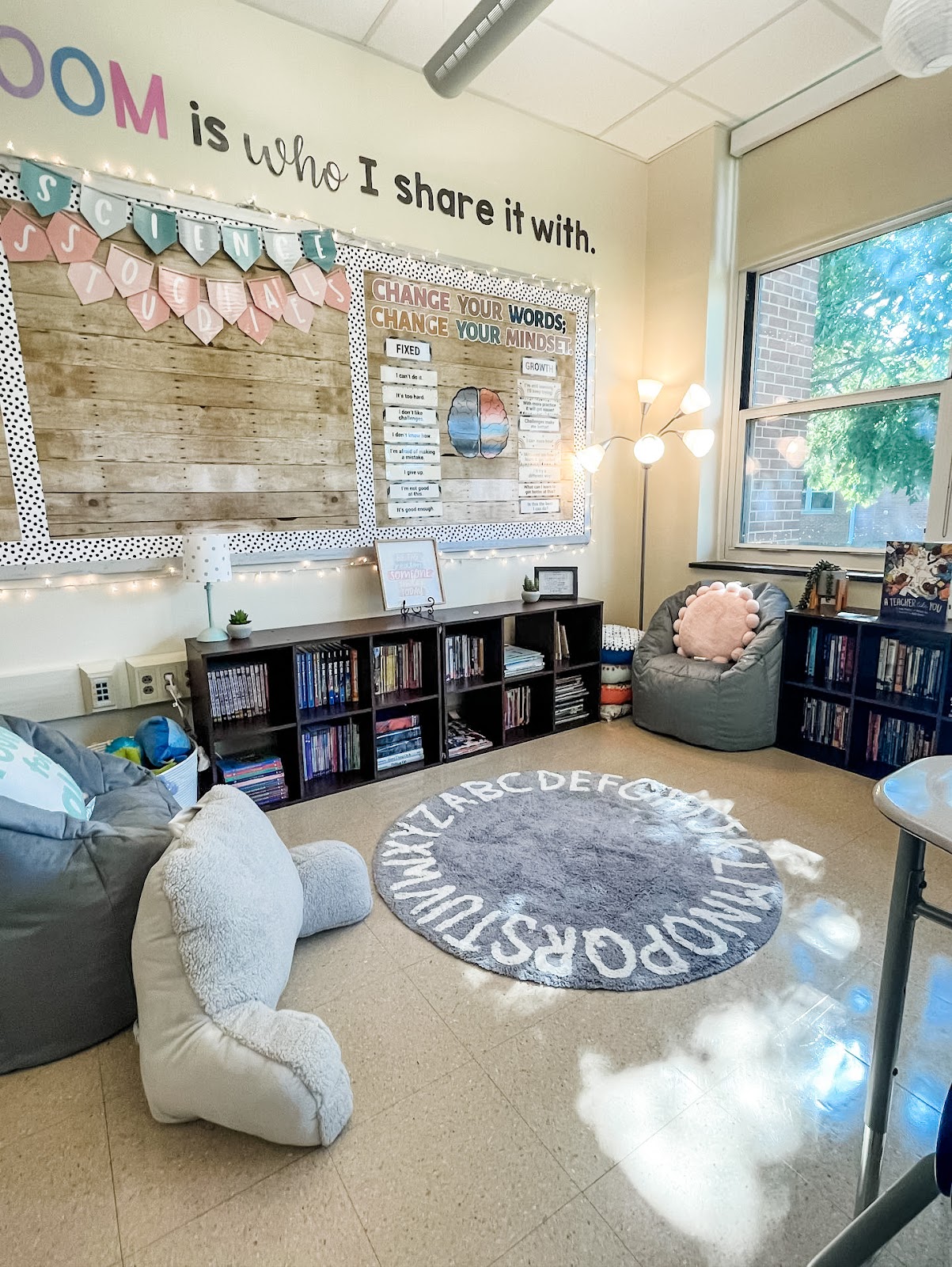 This image shows a cozy reading corner with bean bag chairs, a rug, and a floor lamp. 