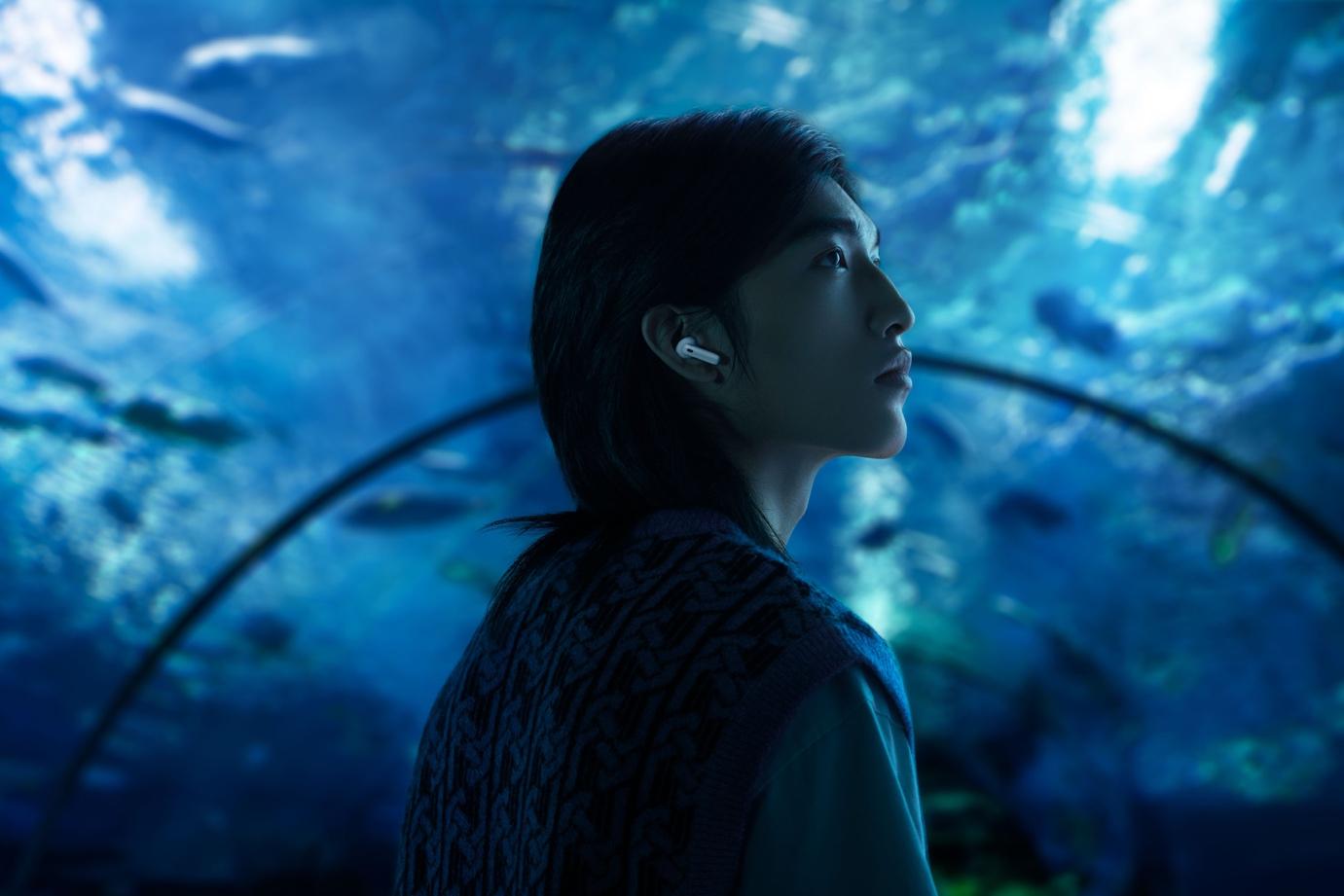 A person looking up at a blue background

Description automatically generated with medium confidence