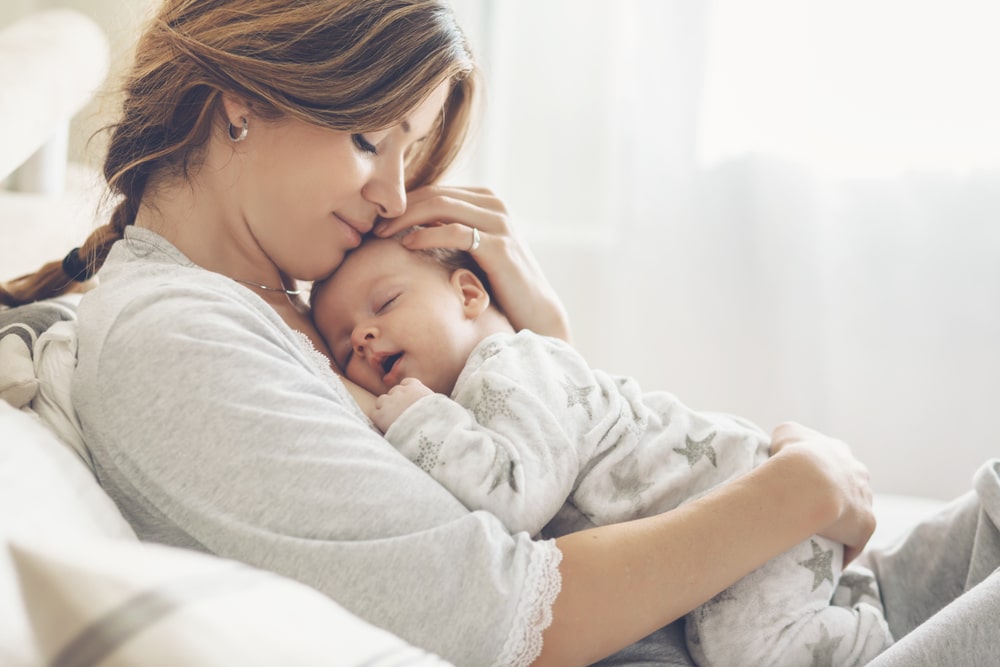 An infant in the arms of its mother