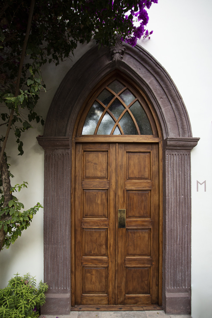 wooden double doors with a glass-paned arch above