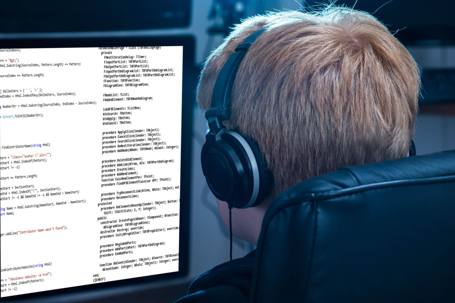 A kid wearing headphones coding on a pc