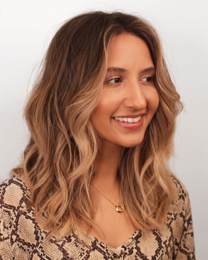 Picture of a lady wearing the Caramel  lob with highlights 