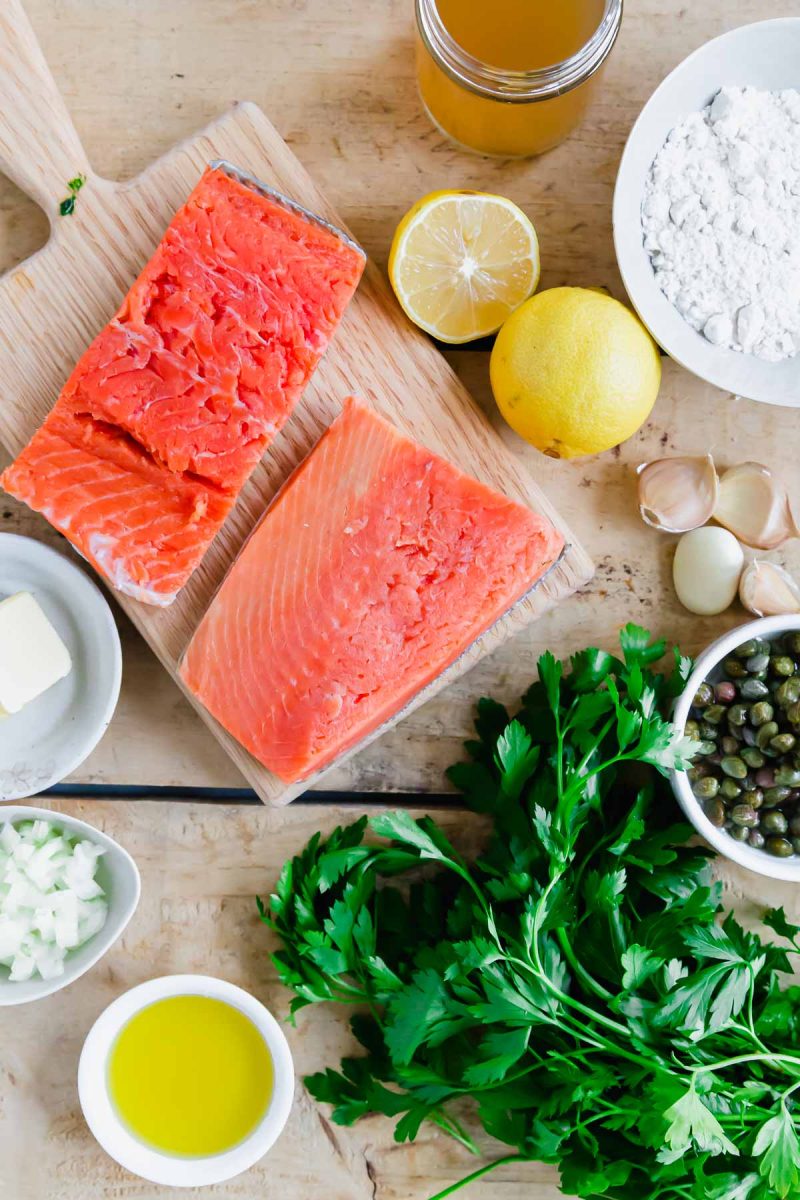 Salmon piccata on a wooden table.