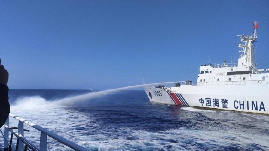 , a Chinese Coast Guard ship, right, uses its water cannons on a Philippine Bureau of Fisheries and Aquatic Resources (BFAR) vessel as it approaches