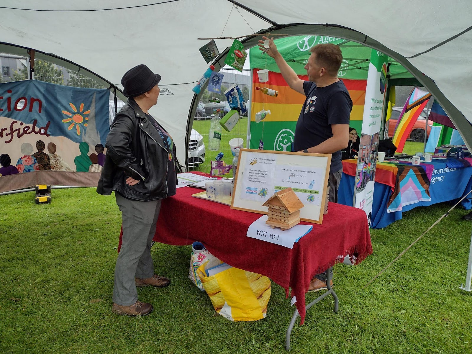 The Transition stall at Chesterfield Pride, where a volunteer is highlighting a display about plastic waste.