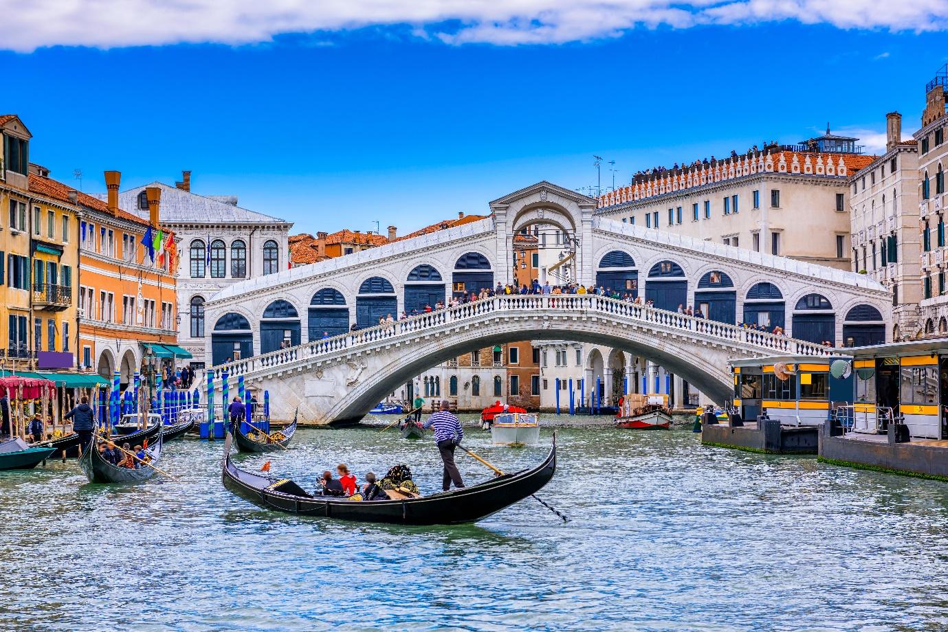 Rialto Bridge over a canal with boats and buildings

Description automatically generated