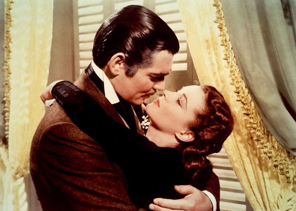 Scarlett O'Hara abrazando por el cuello a Rhett Butler en Lo que el viento se llevó