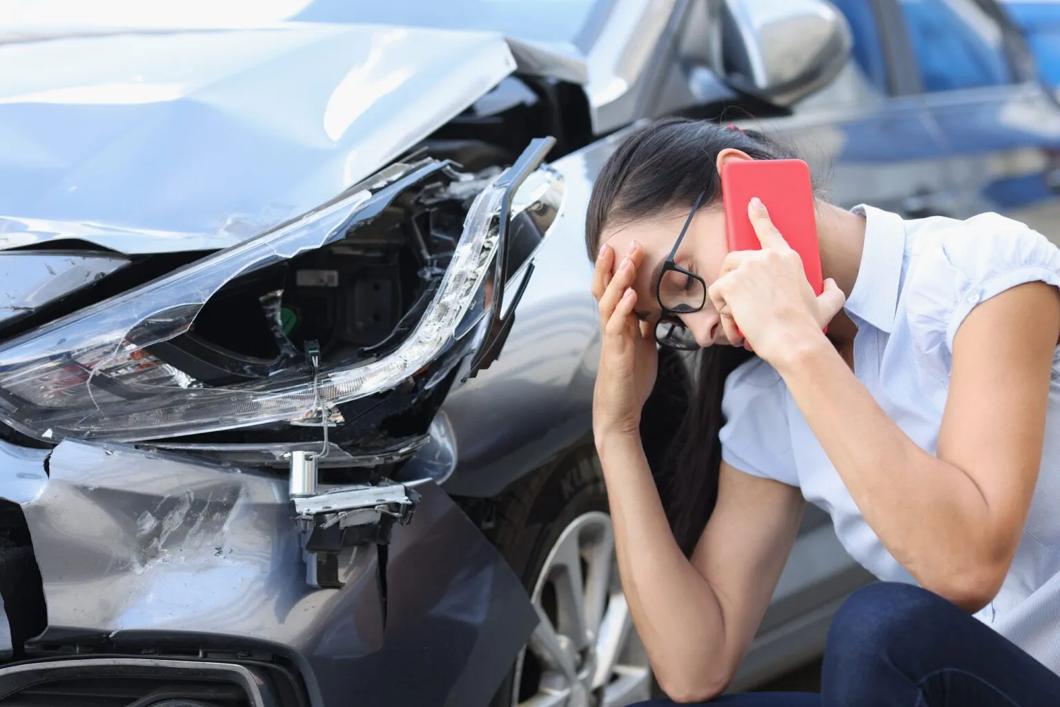woman on the phone after a car accident in florida looking at her damaged front end of car, car accident victims theme