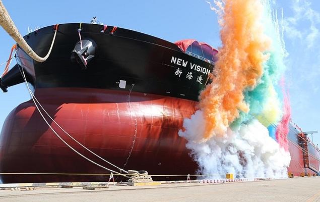 A large ship with colorful smoke coming out of it

Description automatically generated