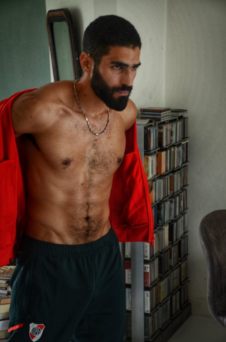 karim yoav removing his red sweatshirt and revealing his hairy chest