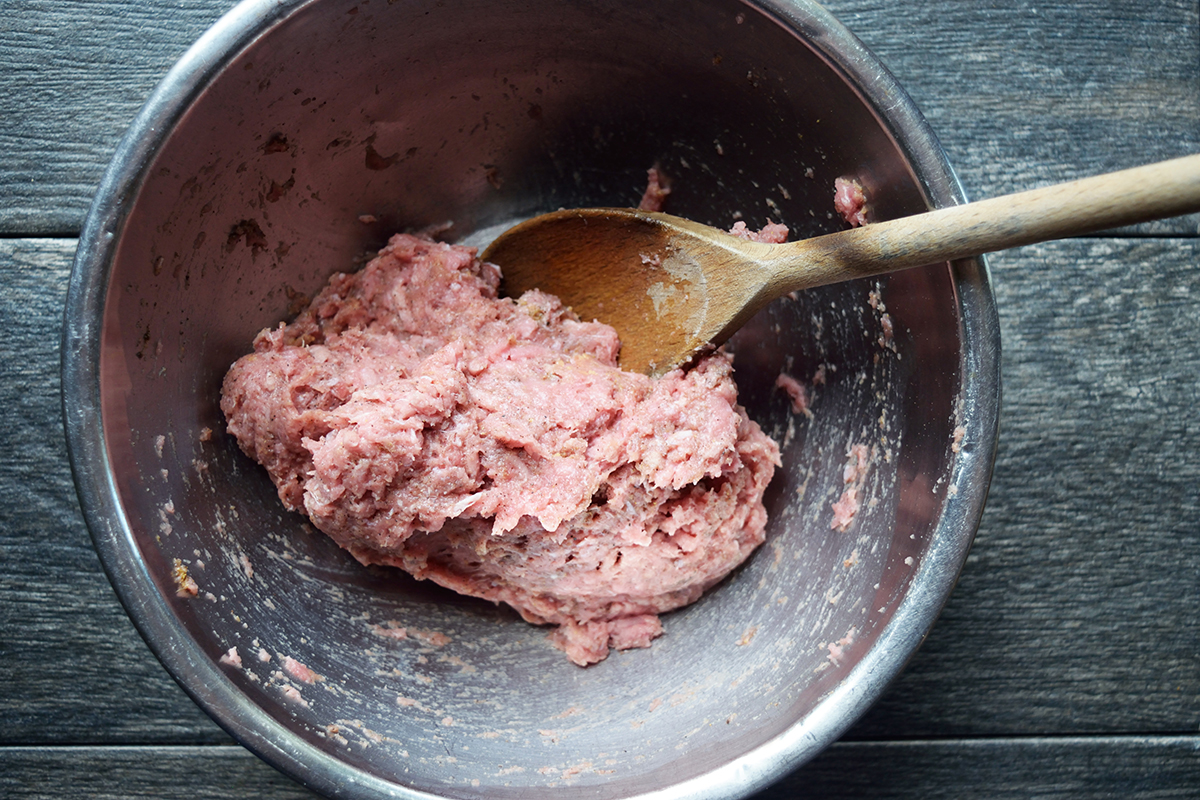 Air fried turkey burgers prepared in a metal bowl with a wooden spoon.