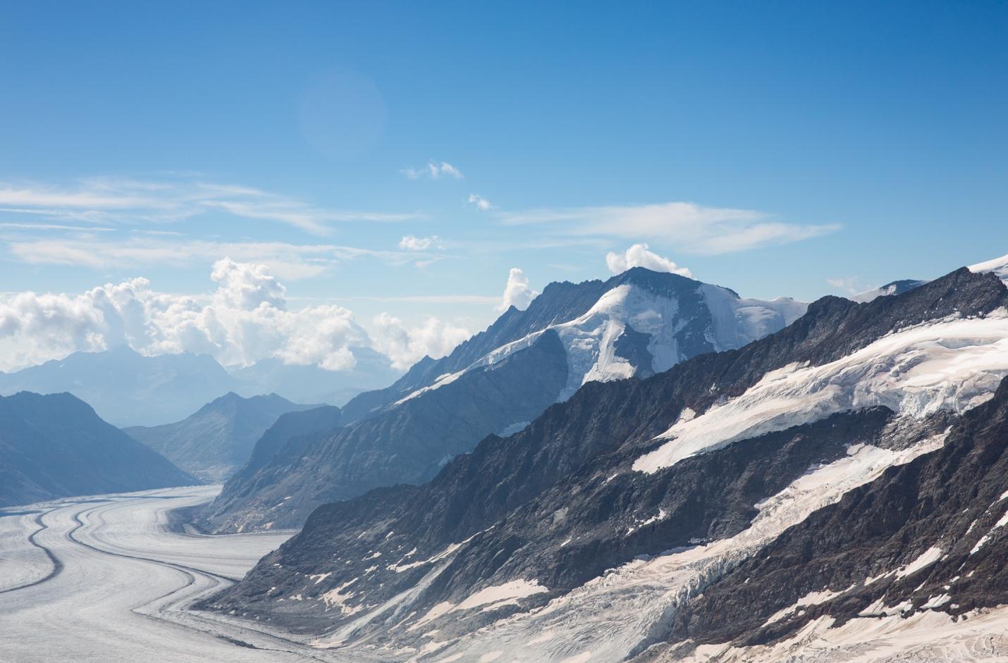 A mountain range with snow and clouds

Description automatically generated