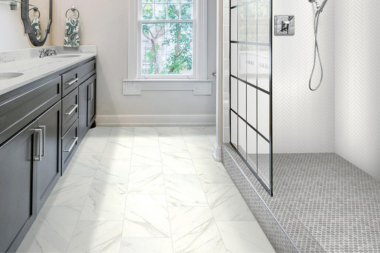 Are you facing a dilemma when selecting the ideal flooring for your bathroom makeover? You may feel uncertain about which of the many options will best meet your requirements.  If you don't understand the pros and cons of each flooring type, you might end up making the wrong choice or one that requires repairs later on.   With 15 years in the business, we've helped hundreds of clients make smart decisions that match their budgets and lifestyles. We’ve seen how the right flooring can elevate a space, and we're here to offer our expertise to guide you. Don't let indecision hinder your progress toward achieving the bathroom you've always envisioned!  In this article, you'll learn more about the pros and cons of five common bathroom flooring options for your remodel: Ceramic Tile Flooring Porcelain Tile Flooring Natural Stone Flooring Vinyl Flooring Linoleum Flooring    Ceramic Tile Flooring  PC: Residential Products Online Ceramic flooring is a popular choice for bathrooms due to its durability, versatility, and wide range of design options. While like porcelain in many respects, ceramic tile has unique characteristics. Pros: Affordability: Ceramic tile is more affordable than porcelain tile for cost-oriented homeowners. Variety: Ceramic tile comes in a vast array of colors, patterns, and textures, allowing you to achieve any look you desire for your bathroom. Durability: Ceramic tile is durable and resistant to scratches, stains, and water damage. This makes it suitable for use in high-traffic areas like bathrooms. Heated Flooring: One of the unique features of ceramic flooring is its thermal conductivity, which makes it a prime option for heated flooring installations (perfect for cold winter nights!). Cons: Porosity: Ceramic tile is more porous than porcelain tile. This makes it more susceptible to water absorption and staining if not sealed. Chip Prone: While durable, ceramic tile may be more prone to chipping or cracking if heavy objects are dropped. Grout Lines: Grout lines can be harder to clean and need regular upkeep to stop stains and color changes.  Porcelain Tile Flooring  PC: TileBar Porcelain flooring is strong, durable, and easy to maintain, making it great for bathrooms with moisture and wear issues. Pros: Strength: Porcelain tile is more dense and stronger than ceramic tile, making it resistant to chips, cracks, and scratches. Low Porosity: Porcelain tile is less porous than ceramic tile. This makes it impervious to water absorption and staining when sealed. Versatility: Porcelain tile comes in a wide range of colors, patterns, and finishes. This includes options that mimic the look of natural stone or wood. Cons: Cost: Porcelain tile is generally more expensive than ceramic tile. Weight: Porcelain tile is heavier than ceramic tile. This means it will require additional support during installation. Installation Complexity: Porcelain tile can be harder to cut and install than ceramic tile. This extra step raises labor expenses.  Natural Stone Flooring  Natural stone flooring, such as marble, offers unparalleled elegance and luxury to bathroom spaces. Yet, it also comes with its own advantages and disadvantages that homeowners should consider before making a decision. Pros: Luxurious Aesthetic: Natural stone flooring adds timeless beauty and a luxurious feel to your bathroom. Unique Variations: Every natural stone piece is unique. With exquisite patterns, colors, and veining, they feature aesthetics man-made stone can't copy. Longevity: With proper care, natural stone flooring can last a lifetime. This makes it a smart investment if you're looking for durable options. Cons: Cost: Natural stone flooring is one of the most expensive options on the market.  Maintenance Requirements: Needs regular sealing to prevent stains and water damage. It may also need more intensive cleaning and maintenance than ceramic or porcelain tiles. Slippery Surface: Some types of natural stone flooring can be slippery when wet. This poses a potential safety hazard.  Luxury Vinyl Flooring  PC: Signature Floors Luxury vinyl flooring, known as LVT (luxury vinyl tile) or LVP (luxury vinyl plank), has become increasingly popular as a budget-friendly substitute for traditional tile and stone materials. While it presents numerous benefits, it's important to consider its advantages and limitations before deciding. Pros: Affordability: Vinyl flooring is one of the most budget-friendly options available. This makes it an ideal option if you're on a tight budget. Water Resistance: Most vinyl flooring options are waterproof or water-resistant. This makes them suitable for moisture-prone areas like bathrooms. Easy Installation: Vinyl flooring is easy to install, especially compared to ceramic or porcelain tiles. DIY remodelers often use vinyl flooring for their projects. Cons: Durability: Vinyl floors resist scratches and dents but might not last as long as ceramic or porcelain tiles. Limited Design Options: Vinyl flooring offers different colors and patterns. While emerging brands continue to bring improvement to the look and quality of this product, LVT/LVP will not be a replica of stone or wood. Vulnerability to Damage: Can still get scratched, torn, or dented by sharp objects or heavy furniture, causing damage over time.  Linoleum Flooring  PC: The Spruce Linoleum flooring offers a durable, eco-friendly, and budget-friendly option for homeowners seeking an alternative to traditional tile or vinyl flooring. However, it also has its own set of advantages and disadvantages to consider. Pros: Environmentally Friendly: Linoleum flooring is made from natural, renewable materials, including linseed oil, wood flour, and cork dust, making it an eco-friendly choice for environmentally-focused homeowners. Durability: Linoleum flooring is highly durable and resistant to scratches, stains, and water damage, making it suitable for high-traffic areas like bathrooms. Easy Maintenance: Linoleum flooring is easy to clean and maintain, requiring only regular sweeping and occasional mopping to keep it looking its best. Cons: Limited Aesthetic Options: While linoleum flooring comes in various colors and patterns, it may not offer the same range of design options as other flooring materials like ceramic or porcelain tile. Installation Complexity: Linoleum flooring requires professional installation to ensure proper fitting and sealing, adding to the project's overall cost. Potential for Fading: Linoleum flooring may be susceptible to fading over time, especially in areas exposed to direct sunlight, affecting its overall appearance and longevity. Next Steps to Remodeling Your Bathroom If you've been struggling to decide which flooring material to choose for your bathroom remodel, you're not alone. The array of options available can be overwhelming, leaving you unsure which will best meet your needs and preferences.  With a comprehensive understanding of the pros and cons of ceramic, porcelain, natural stone, vinyl, and linoleum flooring, you can make an informed decision.  At Custom Built, we've been assisting homeowners like you in navigating the complexities of bathroom remodels for over 15 years. Our expertise in flooring selection and installation ensures that your project is in capable hands from start to finish.  Ready to transform your bathroom into a space that reflects your style and meets your practical needs? Contact our team of design-build professionals today to discuss your project and take the first step toward realizing your vision.  Now that you know more about common bathroom flooring options, let’s explore the first step of your project with Custom Built, how much your bathroom will cost, and the pros and cons of countertop selections: What is a Discovery Call with Custom Built? - This article details what your first call with Custom Built looks like as you start planning your remodel. How Much Does a Bathroom Remodel Cost in Lansing, Michigan? - Discover accurate price ranges for your potential bathroom remodeling project. Comparing Bathroom Countertop Options for Your Home Remodel - Every successful bathroom remodel includes a gorgeous countertop. Explore the pros and cons of standard countertop options for your remodel ceramic tile floor custom built michigan