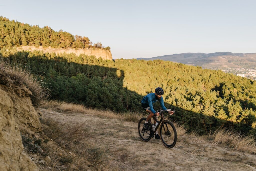 a man riding a bike down a dirt road