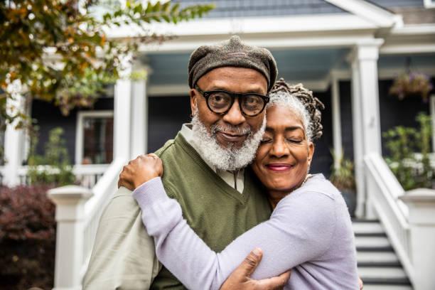 portrait of senior husband and wife in front of suburban home - black lovers stock pictures, royalty-free photos & images