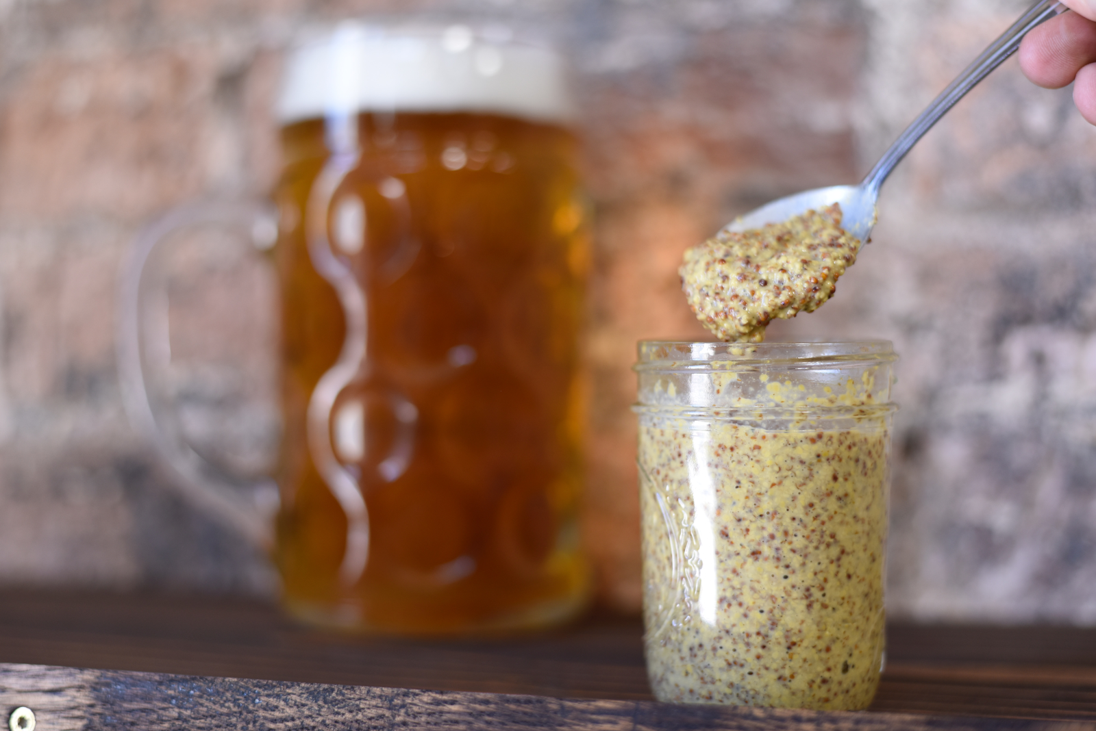 stone ground mustard being spooned out of a jar