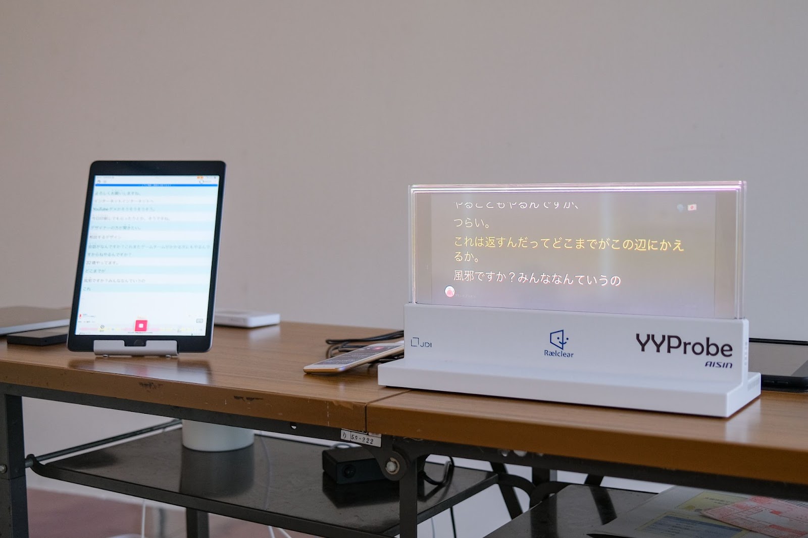 タブレットに表示された文章が、透明スクリーンのデバイスに表示されている。