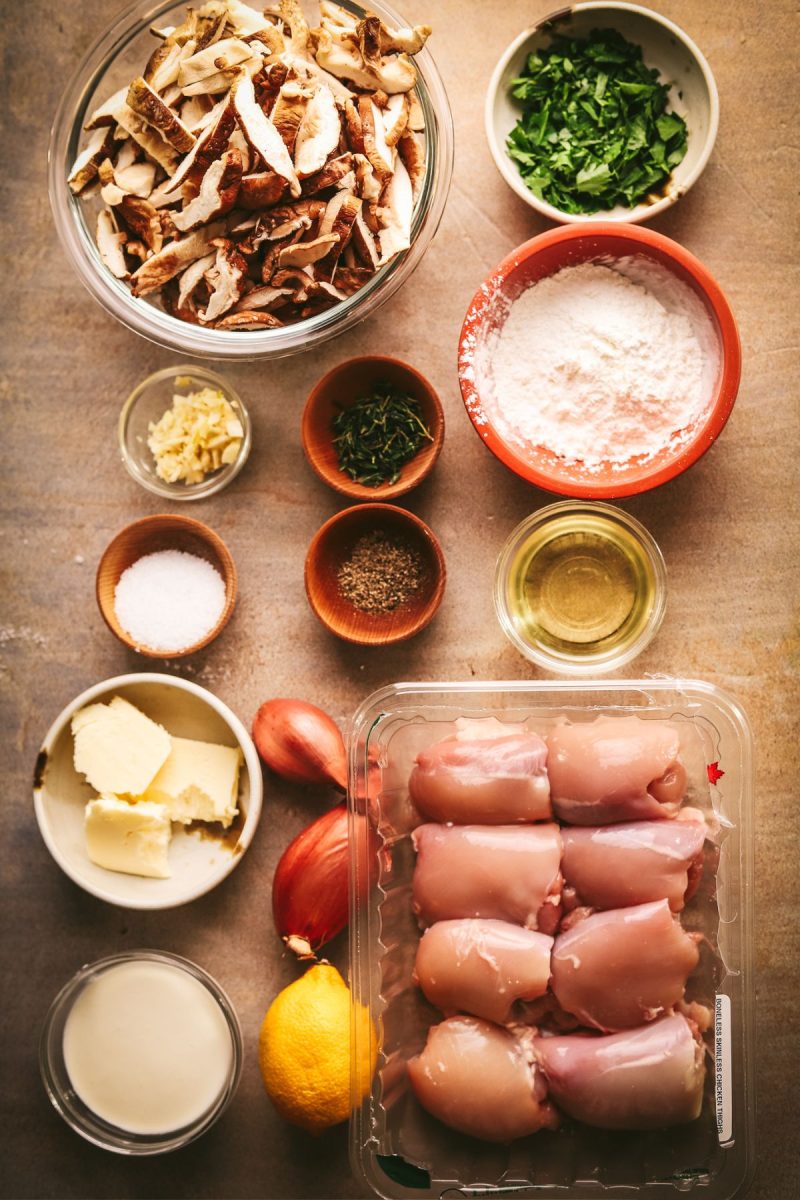 The ingredients for a champagne chicken recipe are laid out on a table.