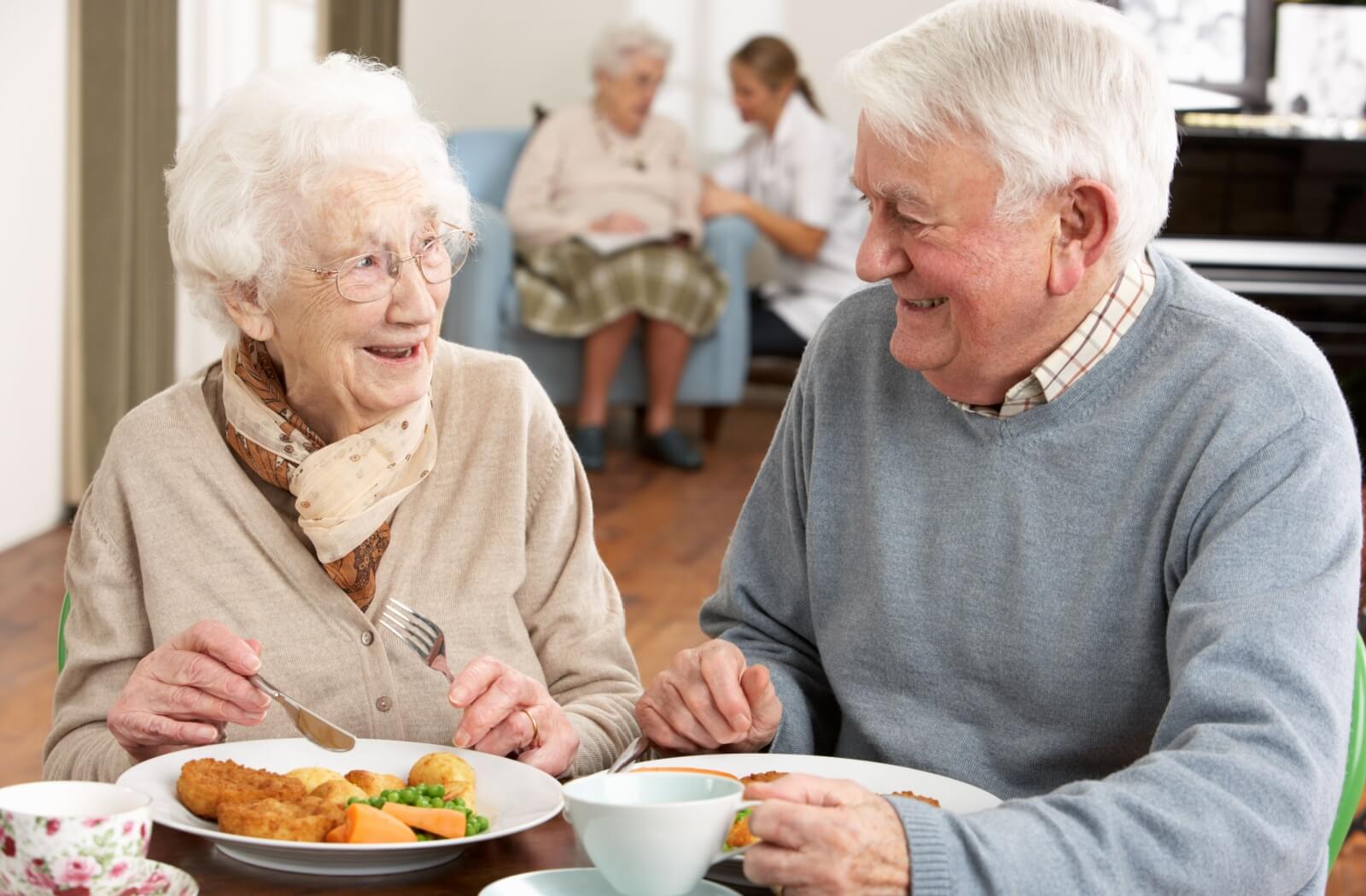 An older adult couple enjoying a delicious meal.