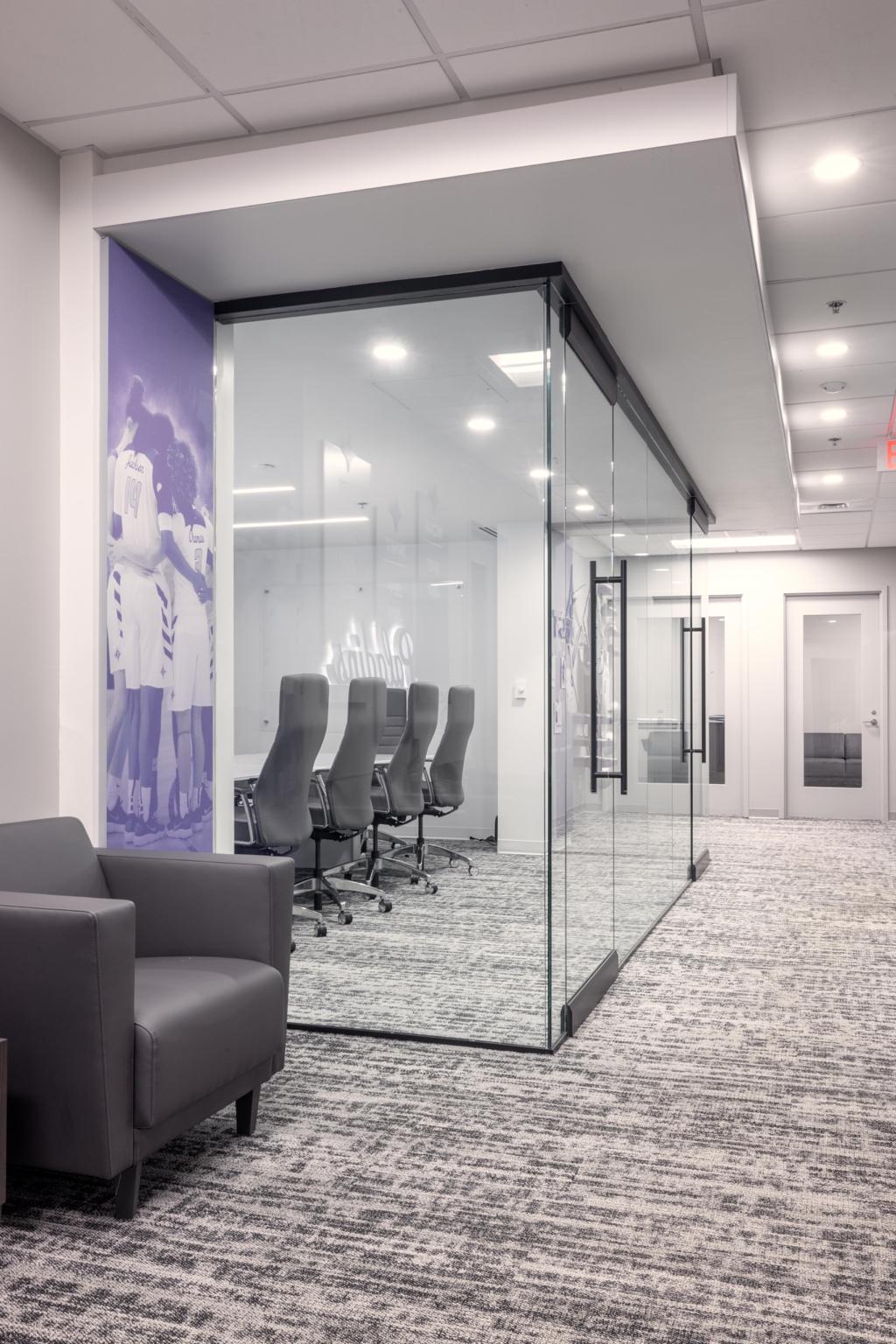 A glass wall with chairs in the middle of a room

