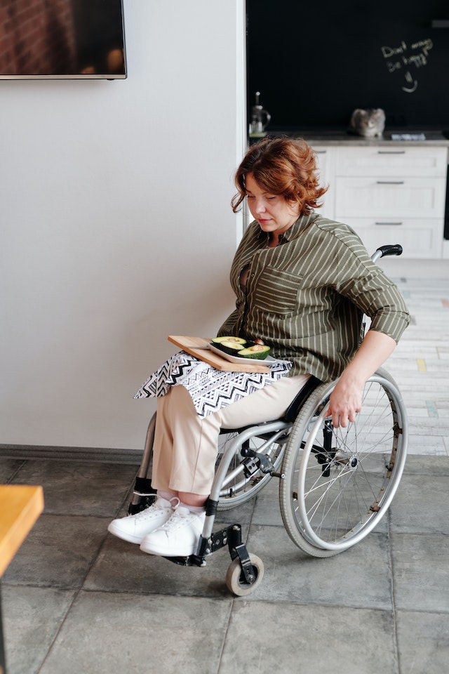 A patient in a wheelchair with her fruit serving.