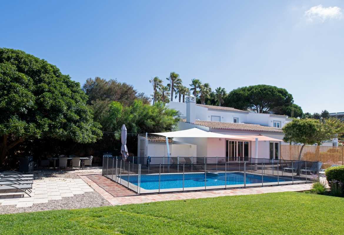 Side view of a villa with a shaded swimming pool.