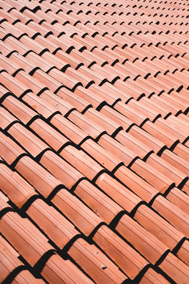 A sloping roof with red roof tiles stacked on top of each other