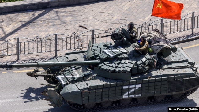 Російський танк під час вторгнення. Під прапором неіснуючого СРСР. 2022 рік